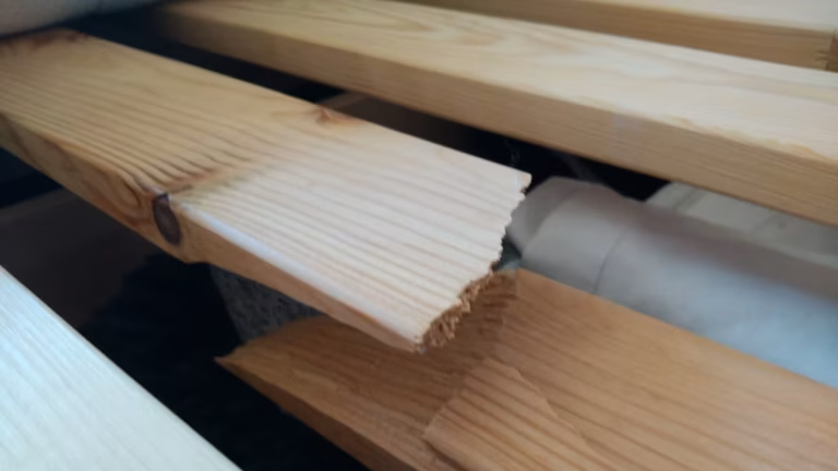 DIY repair showing hands fixing wooden bed slats on a bed frame using tools