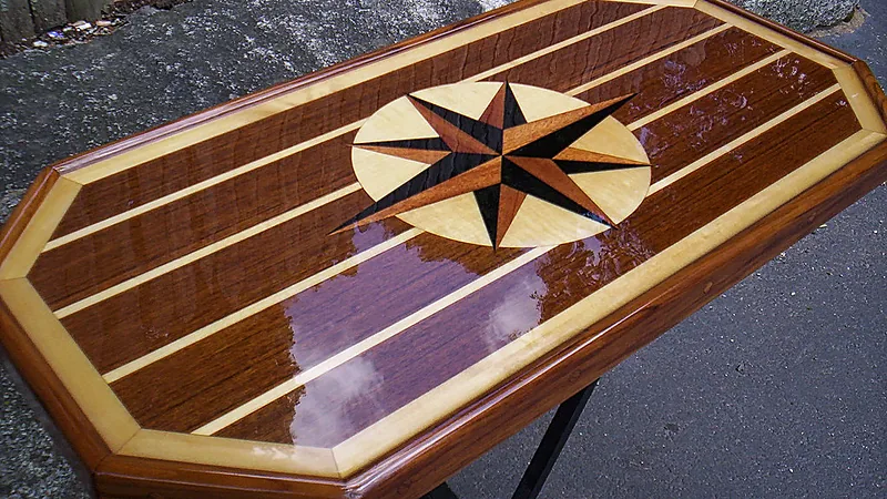 Wooden table finished with a glossy clear epoxy flood coat over an inlaid star pattern