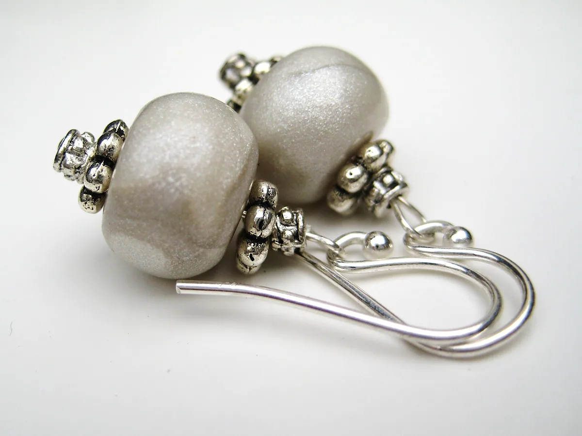 Pair of handmade drop earrings with cream ceramic beads, silver spacer beads and silver ear wires