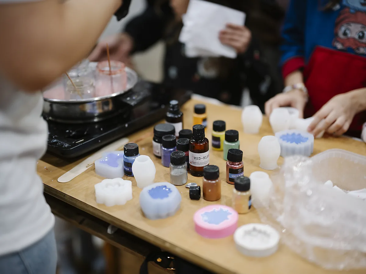 Soap making workshop table with silicone moulds, colour bottles, mica powder and a melting pot