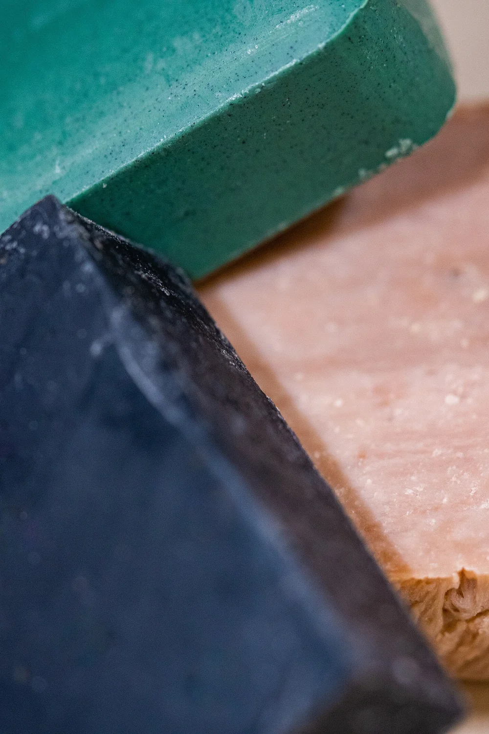 Three hand-cut soap bars in teal, charcoal and oatmeal pink