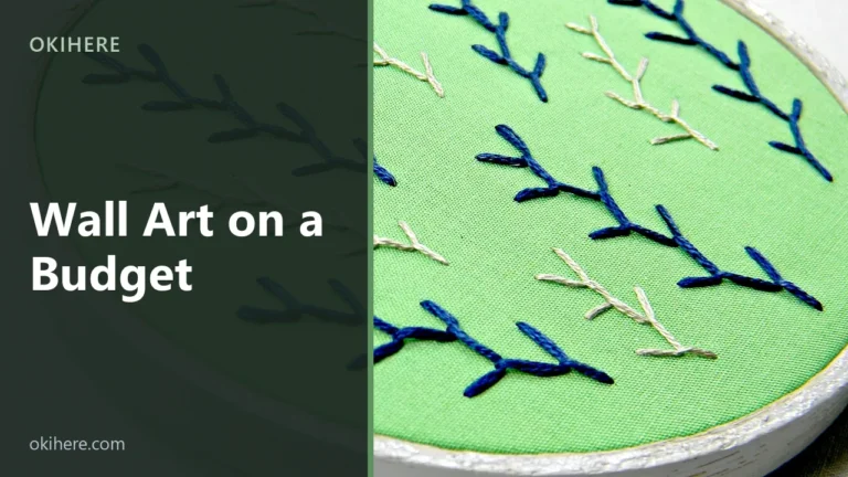 Hand-embroidered hoop art with blue and cream feather stitch on green fabric, with the title Wall Art on a Budget overlaid